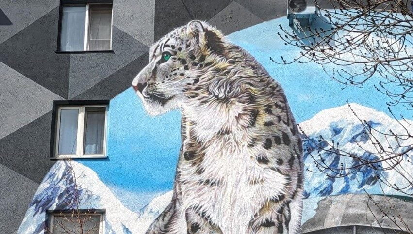 Peinture murale d'un léopard des neiges sur un bâtiment.